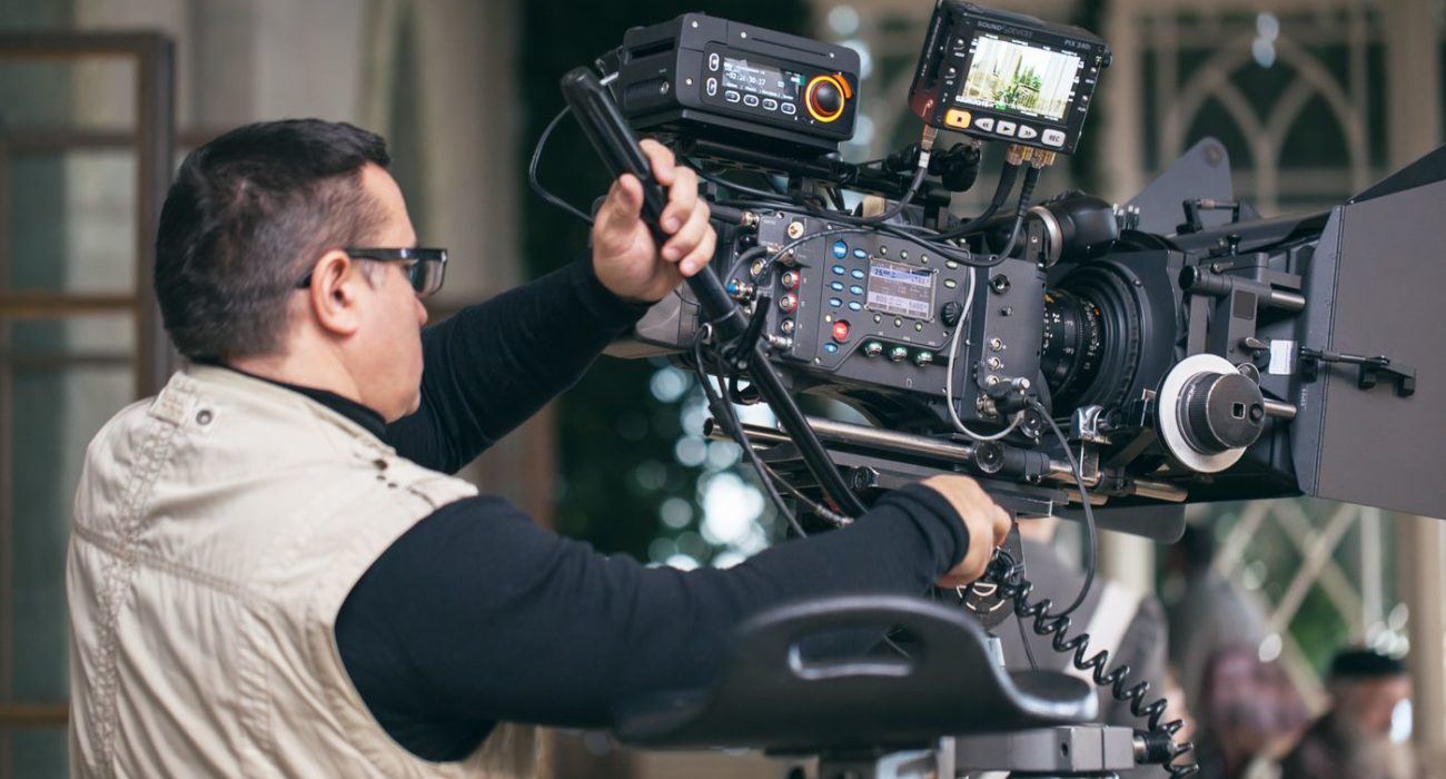 Camera operator with modern professional equipment working during film shooting
